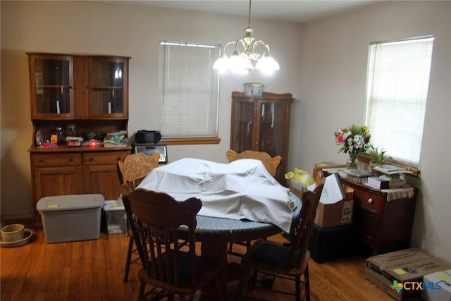 dining area with a chandelier, hardwood / wood-style flooring, and a healthy amount of sunlight