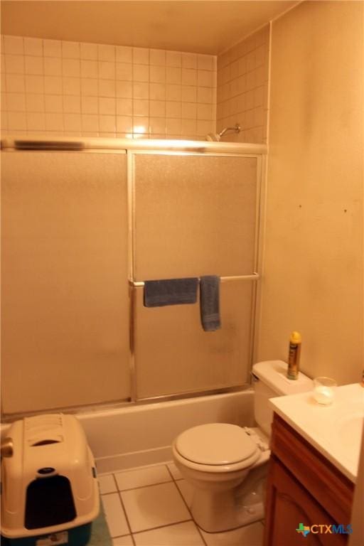 full bathroom with shower / bath combination with glass door, tile patterned flooring, toilet, and vanity