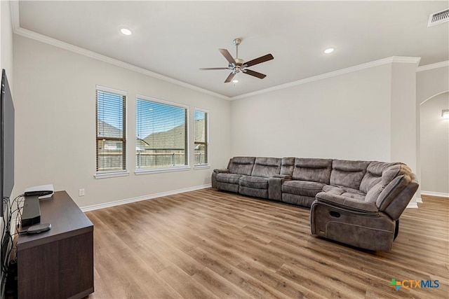 1527 Cobble Hill Ct, Temple, TX 76502 - living area with ceiling fan, arched walkways, light wood finished floors, crown molding, and baseboards
