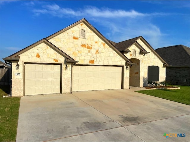 1527 Cobble Hill Ct, Temple, TX 76502 - french country home with stone siding, driveway, an attached garage, and a front yard