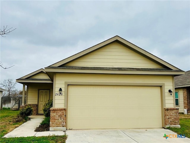 view of front of property with a garage, brick siding, and driveway