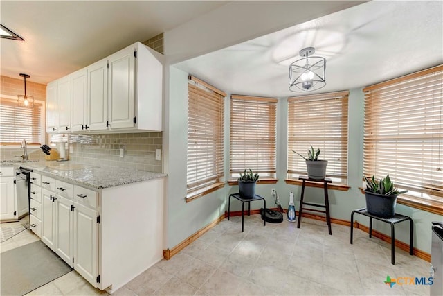 kitchen with tasteful backsplash, decorative light fixtures, and white cabinets