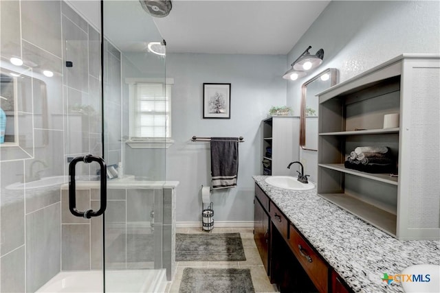 bathroom with a shower stall, vanity, and baseboards