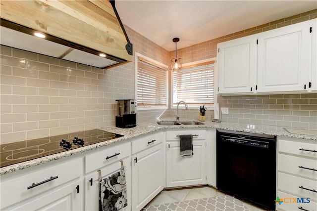 kitchen featuring range hood, decorative light fixtures, white cabinetry, a sink, and black appliances