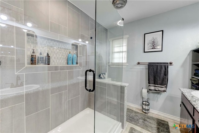 full bath with a shower stall, vanity, and baseboards