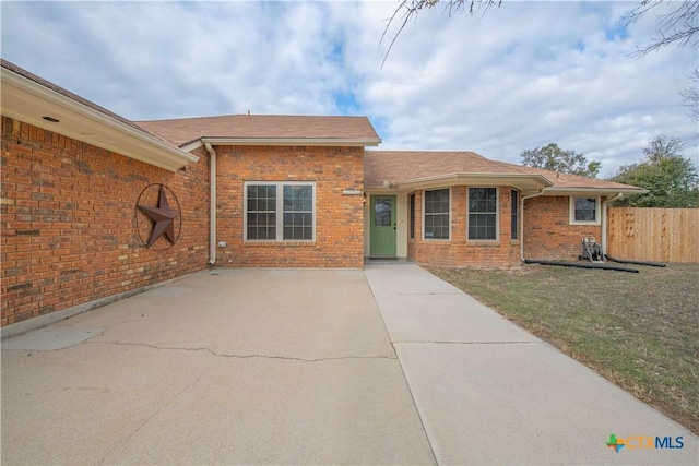 ranch-style home with fence, a front lawn, and brick siding