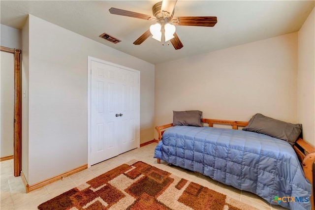 bedroom featuring light tile patterned floors, a closet, visible vents, ceiling fan, and baseboards