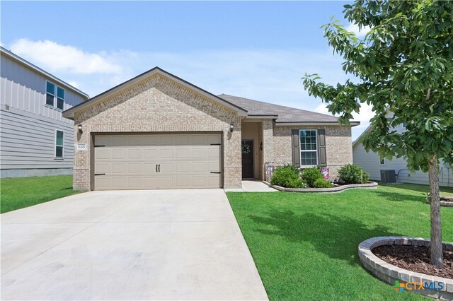 view of front of home with central AC unit, a garage, and a front lawn