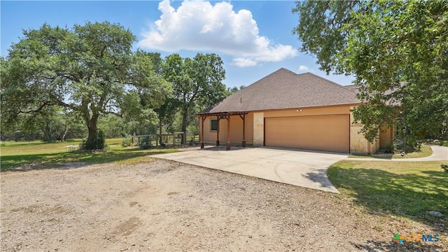 7881 Wegner Rd, New Braunfels, TX 78132 - view of front of property with concrete driveway, an attached garage, stone siding, and a front lawn