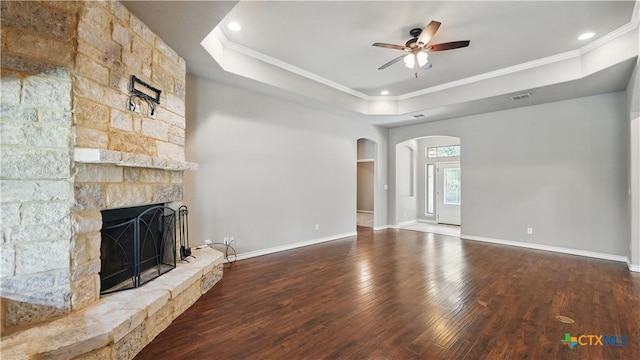 7881 Wegner Rd, New Braunfels, TX 78132 - unfurnished living room featuring a raised ceiling, ornamental molding, a ceiling fan, arched walkways, and wood finished floors