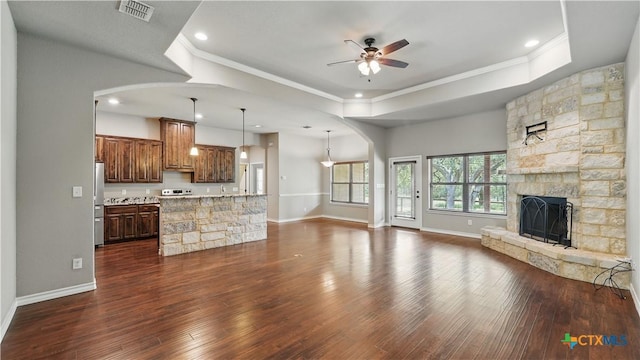 7881 Wegner Rd, New Braunfels, TX 78132 - unfurnished living room featuring a ceiling fan, ornamental molding, dark wood-style floors, a raised ceiling, and baseboards