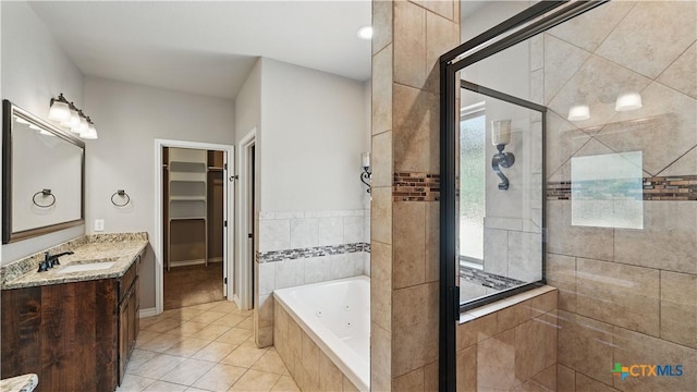 7881 Wegner Rd, New Braunfels, TX 78132 - bathroom featuring a stall shower, tile patterned flooring, a whirlpool tub, vanity, and a walk in closet