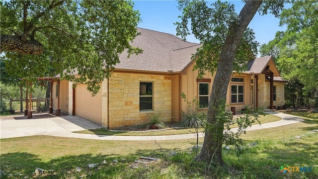 7881 Wegner Rd, New Braunfels, TX 78132 - view of front facade featuring concrete driveway, stone siding, roof with shingles, and a front yard