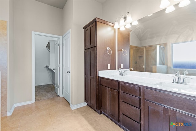 bathroom with a chandelier, vanity, tile patterned floors, and an enclosed shower