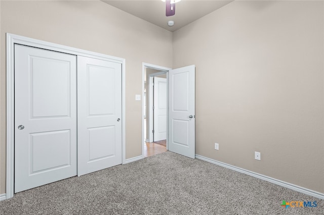 unfurnished bedroom featuring ceiling fan, light carpet, and a closet