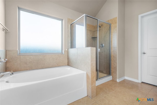 bathroom featuring tile patterned flooring, separate shower and tub, and lofted ceiling