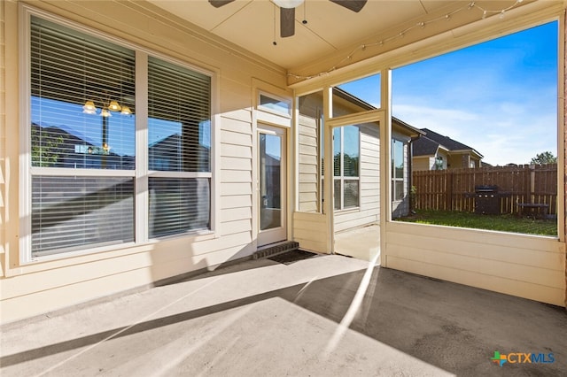 unfurnished sunroom with ceiling fan