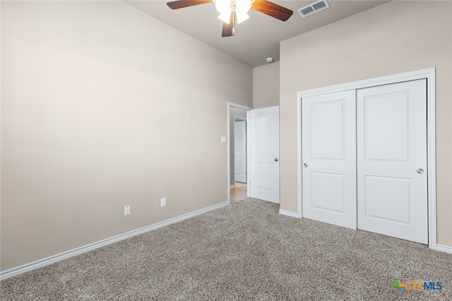 unfurnished bedroom featuring ceiling fan, a closet, and carpet