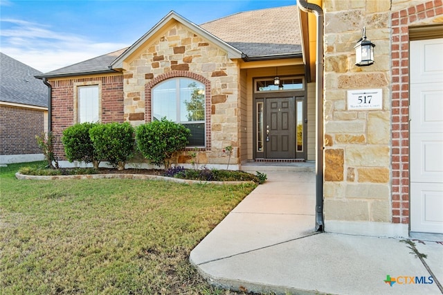 view of exterior entry with a yard