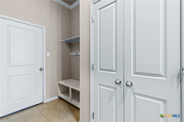 mudroom with light tile patterned flooring and ornamental molding