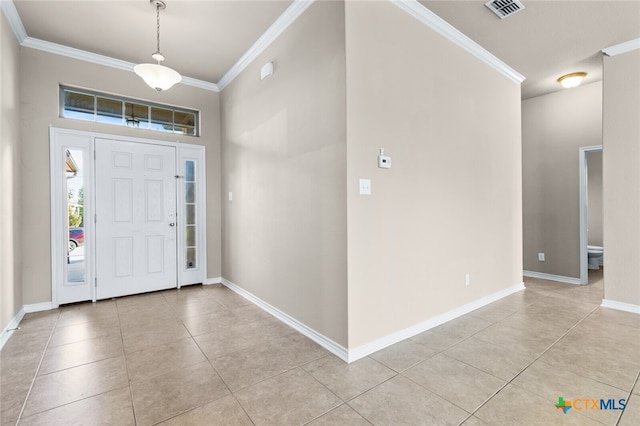 tiled foyer entrance featuring crown molding