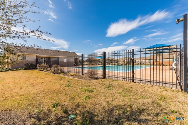 view of swimming pool featuring a patio area and a yard