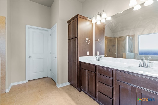 bathroom with tile patterned floors, vanity, an enclosed shower, and an inviting chandelier