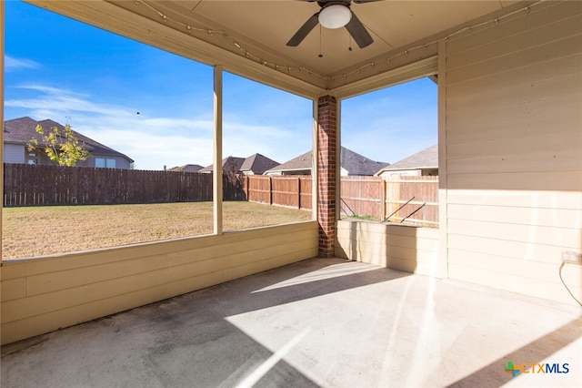 unfurnished sunroom with ceiling fan