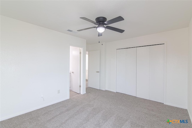 unfurnished bedroom with visible vents, a closet, carpet, baseboards, and ceiling fan