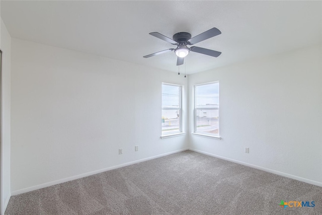 carpeted empty room with ceiling fan and baseboards