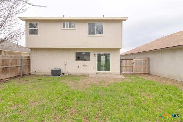 rear view of property with central AC unit, a lawn, and a fenced backyard