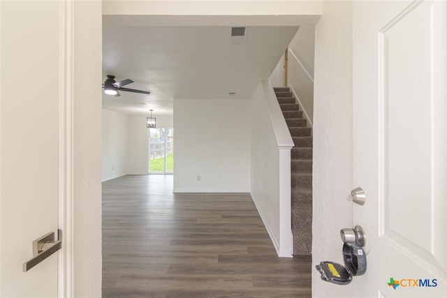 interior space with stairs, dark wood-style floors, visible vents, and baseboards