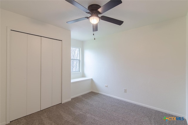 unfurnished bedroom with carpet flooring, a ceiling fan, baseboards, and a closet