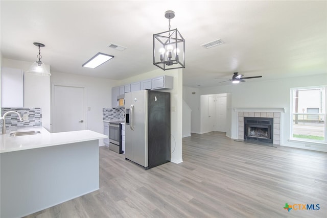 kitchen featuring a tile fireplace, visible vents, appliances with stainless steel finishes, and a sink