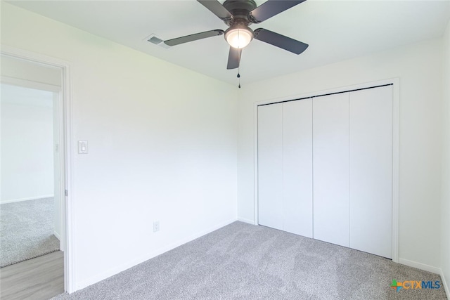 unfurnished bedroom with visible vents, a closet, carpet flooring, baseboards, and ceiling fan