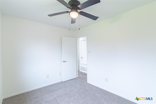 unfurnished room with carpet flooring, visible vents, a ceiling fan, and baseboards