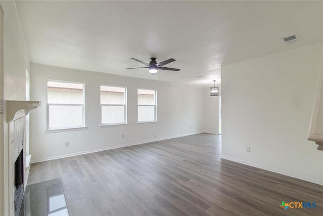 unfurnished living room featuring wood finished floors, visible vents, baseboards, a fireplace, and ceiling fan