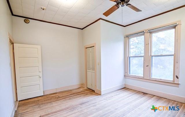 608 N Clinton St, Cuero, TX 77954 - unfurnished room with crown molding, light wood finished floors, and a ceiling fan