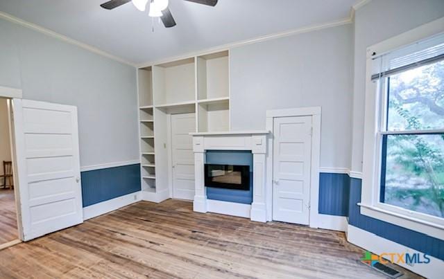 608 N Clinton St, Cuero, TX 77954 - unfurnished living room featuring ceiling fan, wood finished floors, crown molding, and a glass covered fireplace