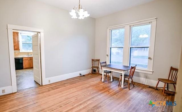 608 N Clinton St, Cuero, TX 77954 - dining area with light wood-type flooring and a chandelier