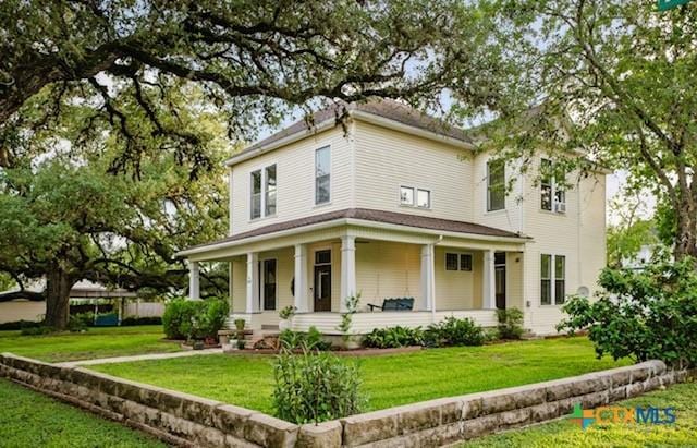 608 N Clinton St, Cuero, TX 77954 - view of front facade featuring covered porch and a front lawn