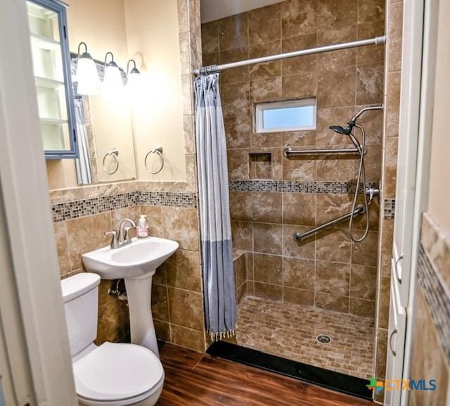 608 N Clinton St, Cuero, TX 77954 - full bath featuring tile walls, tiled shower, and wood finished floors