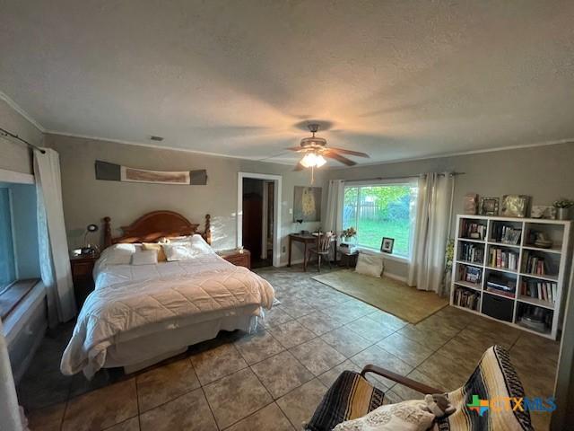 20655 State Highway 195, Killeen, TX 76542 - tiled bedroom with a ceiling fan, a textured ceiling, and ornamental molding