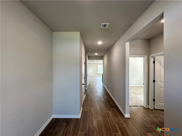 corridor featuring dark hardwood / wood-style flooring and a textured ceiling