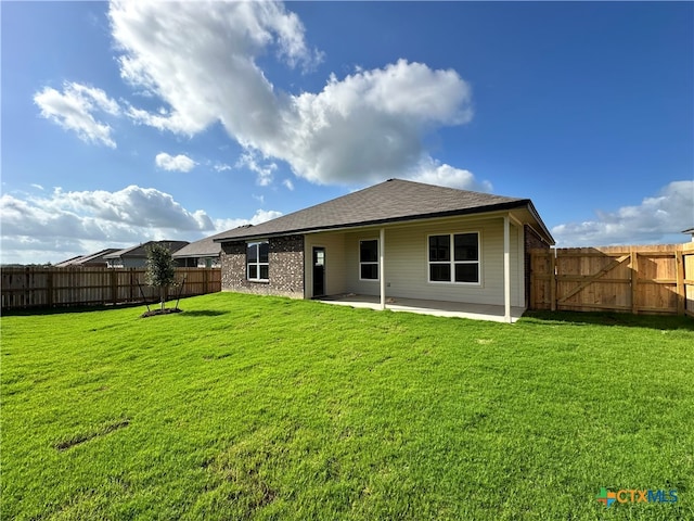 back of house with a lawn and a patio area