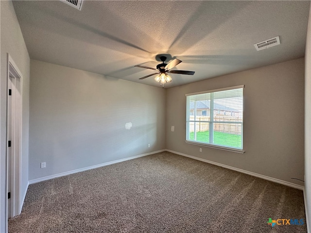 carpeted empty room with ceiling fan and a textured ceiling