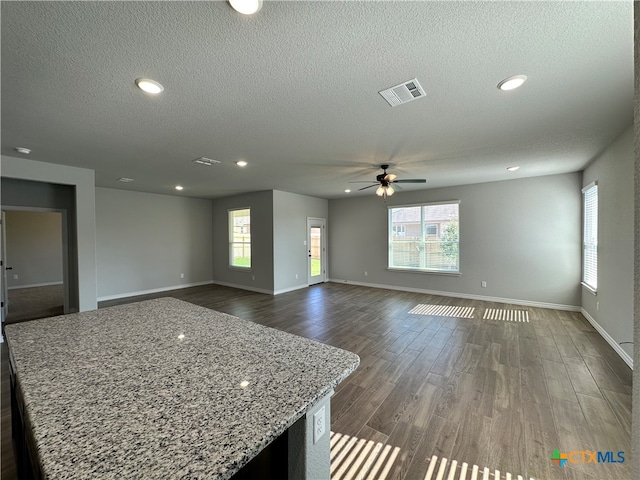 interior space with a textured ceiling, dark hardwood / wood-style floors, and ceiling fan