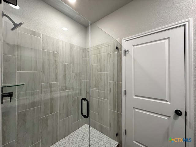 bathroom featuring a shower with shower door