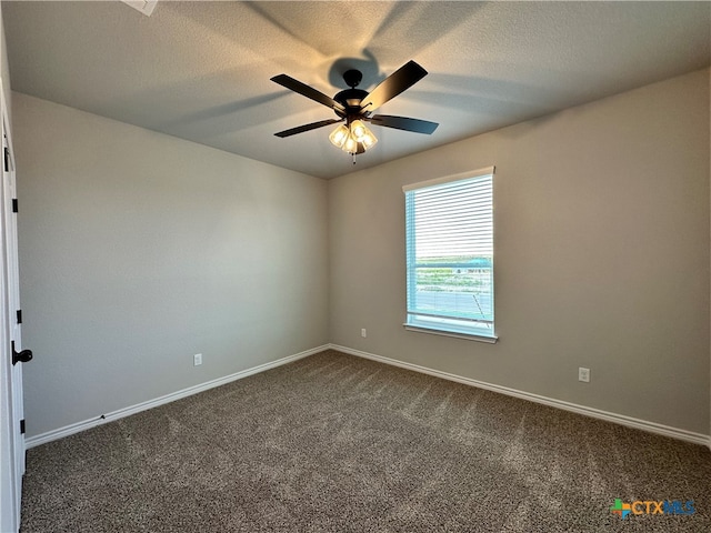 unfurnished room with a textured ceiling, dark colored carpet, and ceiling fan