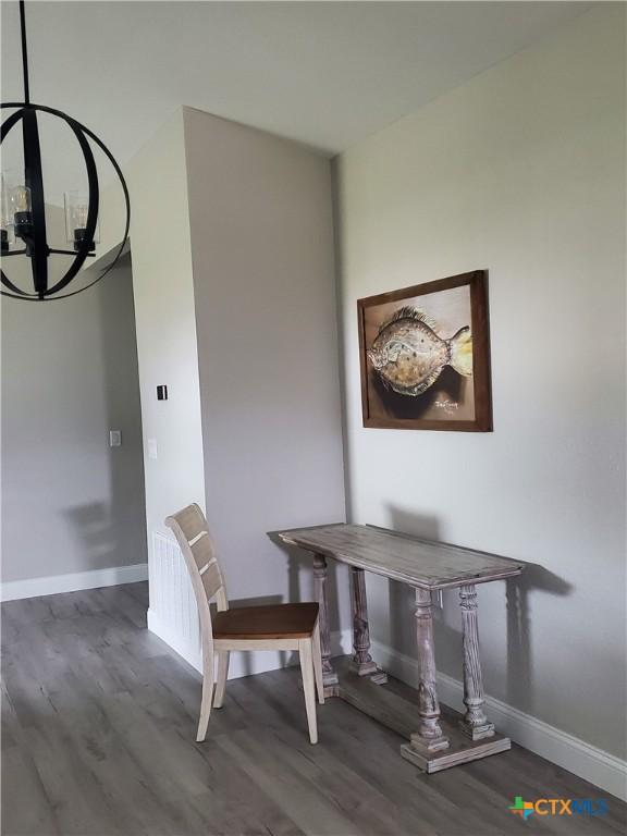 kitchen featuring stainless steel appliances, light hardwood / wood-style floors, white cabinetry, light stone counters, and pendant lighting